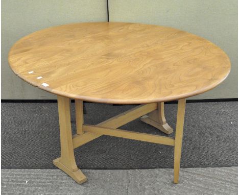 A vintage 1980's golden Ercol Windsor gate leg table of circular form,Nno.610, 72cm x 128cm