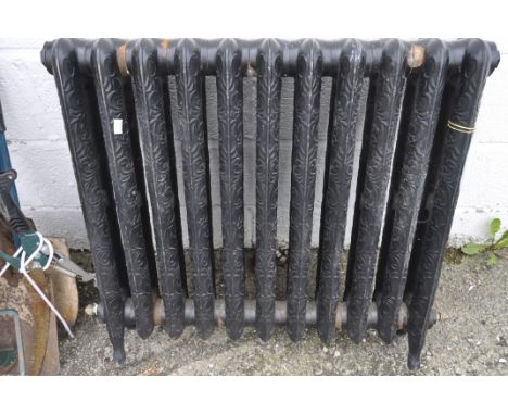 A vintage black painted heavy cast iron radiator, cast with scrolls, raised pattern, 75 cm high x 82 cm wide (AF)