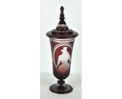 A late 19th century Bohemian ruby glass lidded vase, adorned with detailed engravings depicting a traditional court scene, th