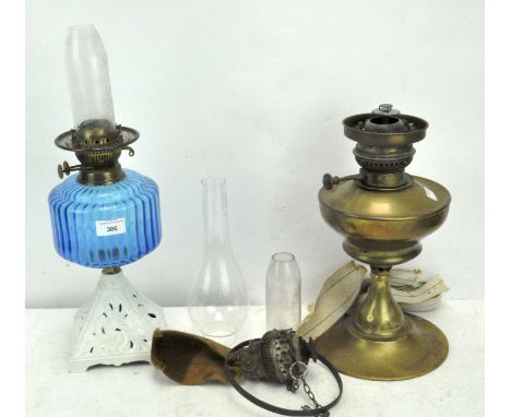 Two vintage oil lamps, one with blue glass and white painted metal base, the other of brass, with spares, 35 cm and 36 cm hig