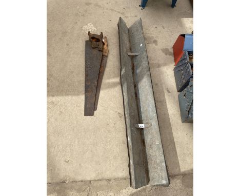 A GALVANISED FEED TROUGH AND TWO WOODEN HANDLED SAWS 