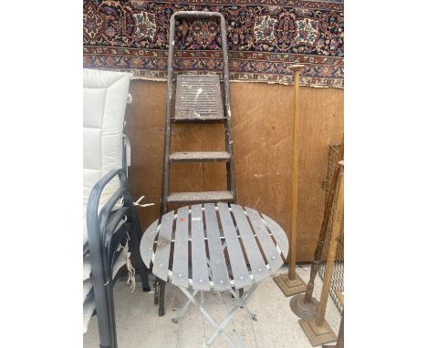 A ROUND METAL FRAMED GARDEN TABLE AND A FOUR RUNG STEP LADDER 