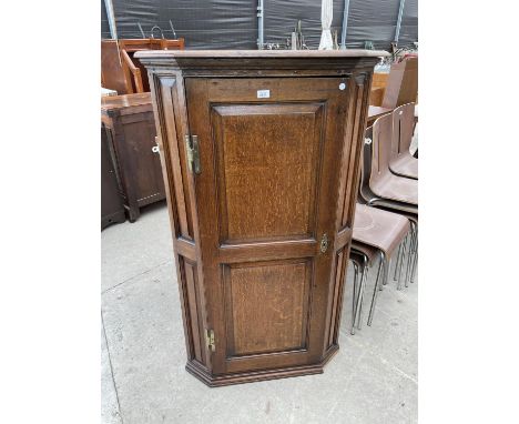 A GEORGE III OAK TWO PANEL CORNER CUPBOARD WITH FOUR BRASS HINGES AND SHAPED SHELVES 