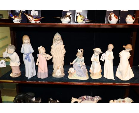 Eight Nao Spanish porcelain figurines of young girls and boys, one playing a violin, the other with a puppy etc. (8)(B.P. 21%