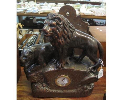 Coloured plaster mantel clock surmounted by a pair of lions. Back-winding movement. 36 cm high approx.(B.P. 21% + VAT) 