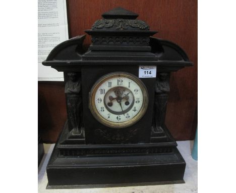 Late 19th century black slate architectural mantel clock having exposed escapement to the two-train movement, the hood with b