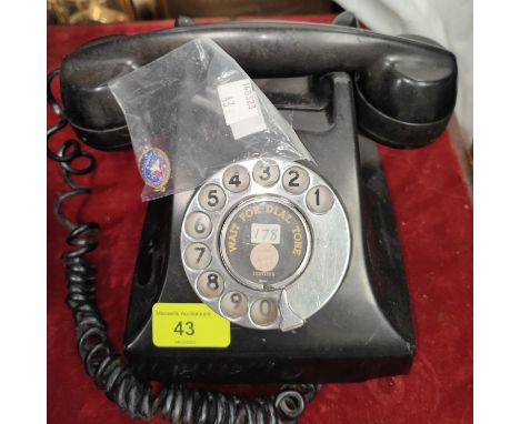 An early 20th century Rotary dial black Bakelite telephone; An enamel egg shaped pendant blue ground with floral decoration
