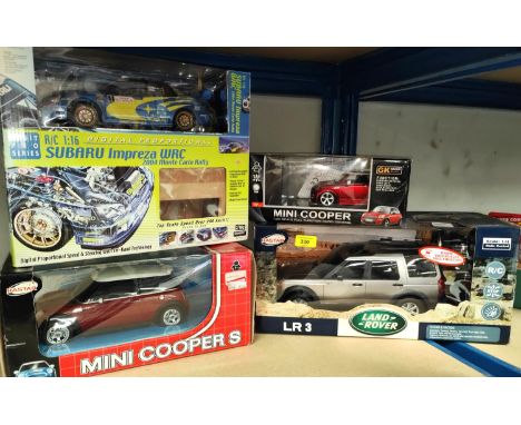 A boxed Rastar radio controlled Land Rover 1:14 scale, two boxed remote controlled Mini Coopers (no controls) and a Subaru Im