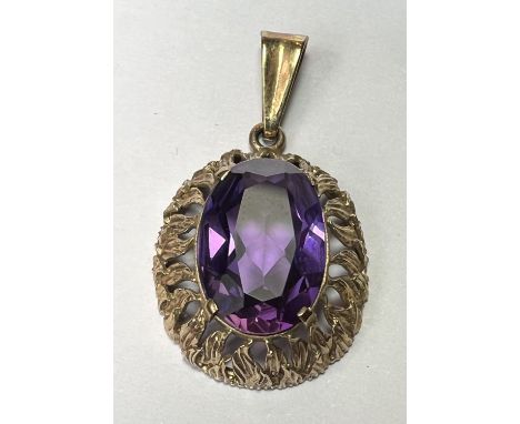 A pendant set with a large amethyst coloured stone, the yellow metal surround stamped 333&nbsp; 