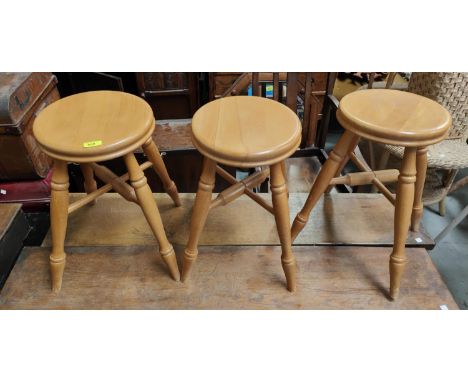 Four modern light wood circular stools on four legs 