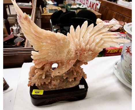 A large cream and brown soapstone depicting a sea eagle diving for a fish on brown ceramic base height 36cm 