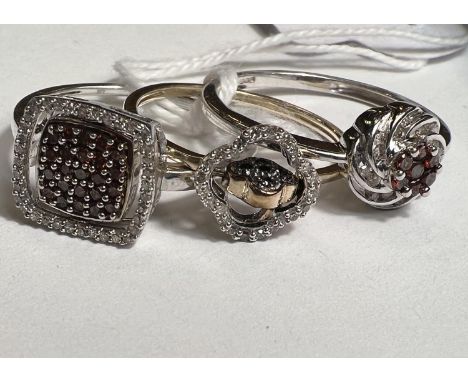 2 9ct hallmarked gold rings set pave style black and clear diamonds, the centre of each swivelling to red/blue stones pave se
