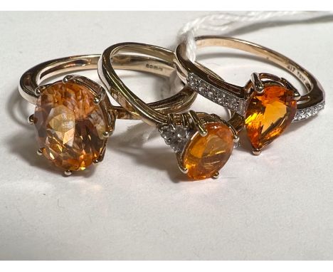 A 9ct hallmarked gold ring set with large oval orange stone Topaz family size R and 2 other 9ct hallmarked gold rings set ora