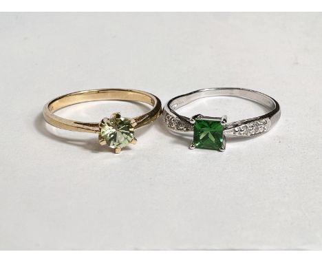 A 9 carat hallmarked gold dress ring set pale green circular peridot, size N; a 9 carat hallmarked white gold dress ring set 