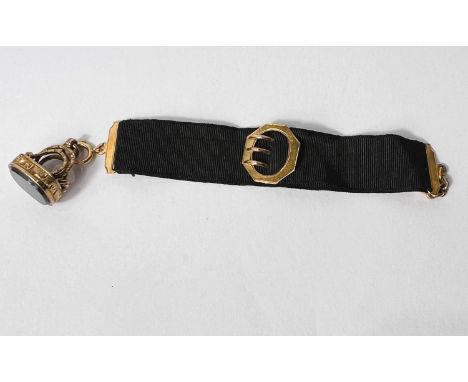 A black silk ribbon with yellow metal clip and buckle; an ornate chased fob with green and red polished agate, gross weight, 