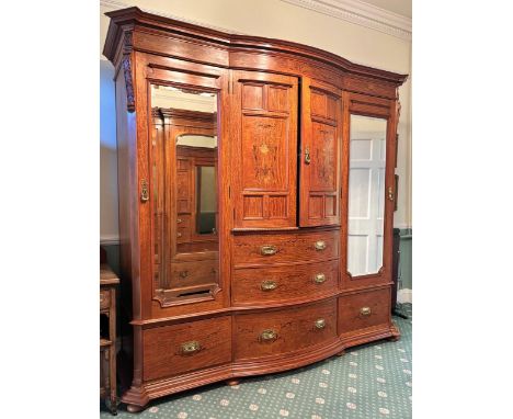 An Edwardian satinwood breakfront wardrobe by Maple & Co, London, the moulded cornice over a frieze inlaid with urn and folia