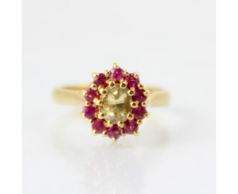 A bespoke untested yellow sapphire and pink spinel cluster ring, the central oval cut untested yellow sapphire within a surro