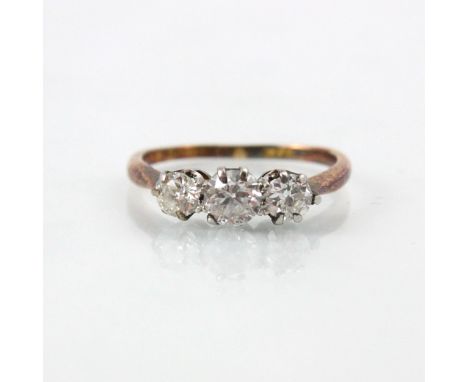 A 20th century diamond three stone ring, the central old cut diamond with smaller diamond to each side, in coronet style moun