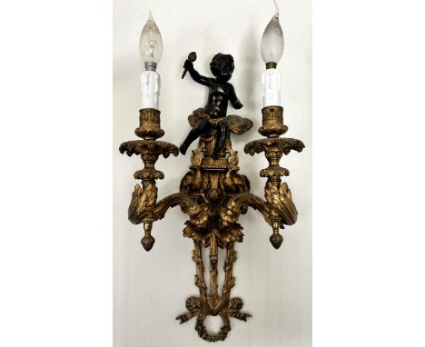 A pair of French ormolu and bronze wall light sconces, each surmounted with the figure of a bronze cherub upon a backplate ca