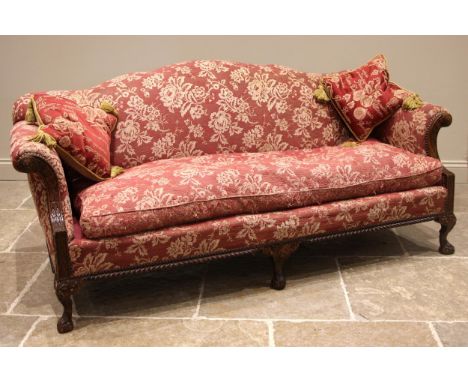 A Chippendale revival sofa, early 20th century, in foliate burgundy fabric, the undulating back rest extending to scrolled ar