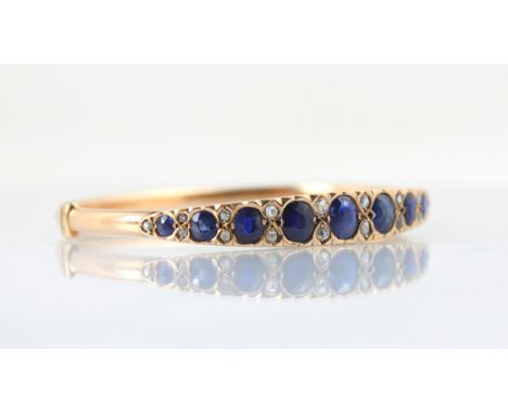 A late 19th century untested sapphire and diamond bangle, the graduated untested sapphire (majority cushion cut) with old cut