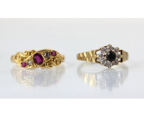 An early 20th century yellow metal ring, the red stone set ring with rose cut diamond detail, set within sinuous mount leadin