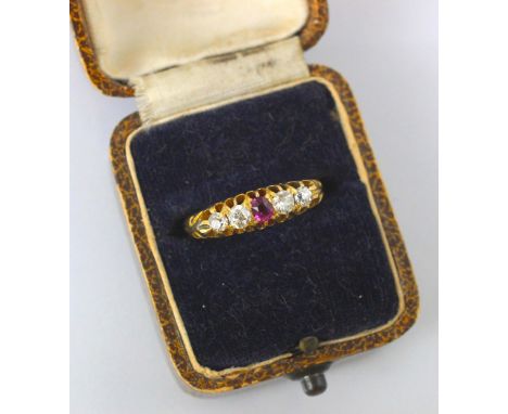 A Victorian 18ct yellow gold Burmese ruby and diamond ring, the central cushion cut ruby with two old diamonds to each side, 