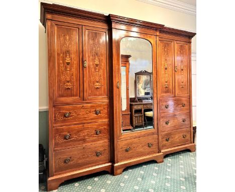 An Edwardian inlaid mahogany gentleman’s compactum wardrobe, by Hampton & Sons, London, of breakfront form, the moulded corni