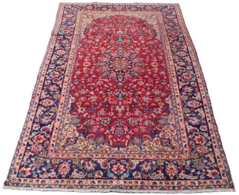 A red and blue ground Persian Najafabad carpet, from the Isfahan region of Iran, with a traditional floral medallion design, 