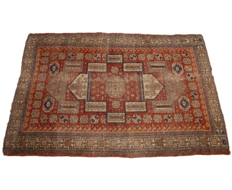 A Turkish hand knotted village rug, the fragmented geometric design upon a central red field, confined by a repeating angular