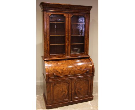 A Victorian burr walnut cylinder bureau bookcase, the moulded and rounded cornice over a pair of glazed doors enclosing three