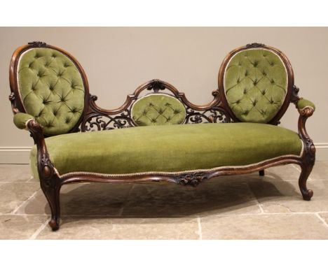 A Victorian walnut framed double spoon back sofa, in green velour, the pair of oval button back rests united by a scrolling o