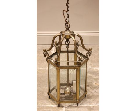 An early 20th century brass hexagonal hall lantern, the central boss extending to six curved supports and a central rod suppo