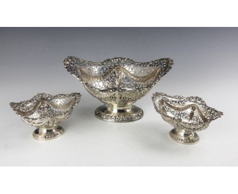 An Edwardian garniture of three silver dishes, George Nathan & Ridley Hayes, Chester 1904, the openwork basket with cast rose
