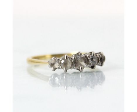 An Edwardian style five stone ring, the five graduated paste stones set in white metal setting edge leading to plain polished