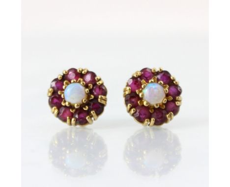 A pair of 9ct yellow gold opal cluster earrings, the central round cabochon opals within surround of eight red stones, with p