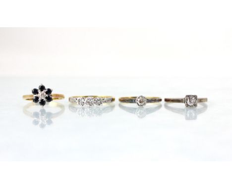 A group of four rings, including an early 20th century diamond solitaire, the old cut diamond in a white metal square setting
