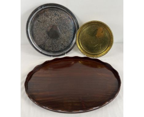 3 vintage serving trays. An oval shaped mahogany tray with scalloped edge (55.5cm long), a silver plated on copper circular t
