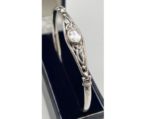 A silver Celtic design bangle set with a central oval cut clear quartz stone. Marked 925 to inside. Approx. 7cm diameter. Tot