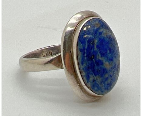 A modern design silver dress ring set with a oval cut cabochon of Lapis Lazuli. 925 stamped to inside of band. Ring size S. 