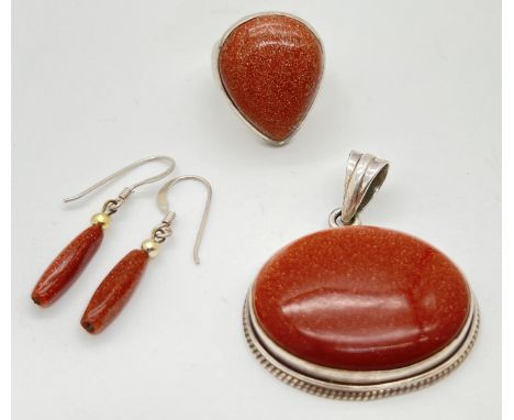 3 pieces of copper goldstone jewellery all set in white metal or silver. A oval pendant in bead work decorative mount, a tear