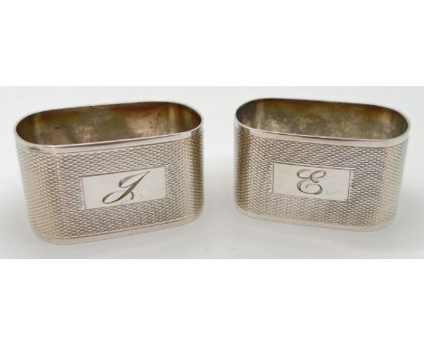 A pair of vintage serviette rings with engine turned decoration and engraved initials to front. Engraved initials J to one, a