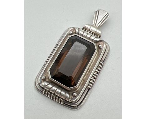 A large rectangular Art Deco style continental silver pendant set with an emerald cut smoked quartz stone. Back of bale marke