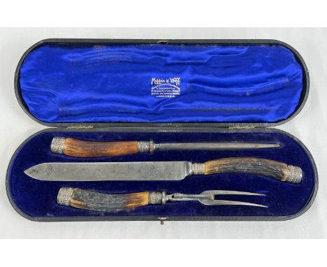 An Edwardian Mappin &amp; Webb carving set with antler handles and white metal decorative collars and ends. In original silk 