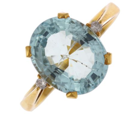 A 14ct gold three stone aquamarine and diamond ring, claw set with 3.6ct oval mixed-cut aquamarine and modern round brilliant