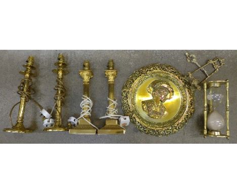 Two pairs of brass table lamp bases, a brass hour glass, a brass stand and a circular brass plaque (7)