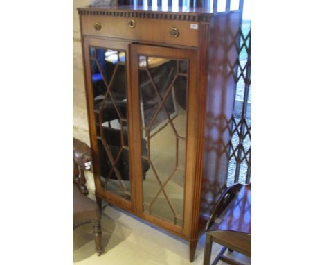 An Edwardian mahogany side cabinet with a single drawer, two astragal glazed cabinet doors raised on square fluted tapering l