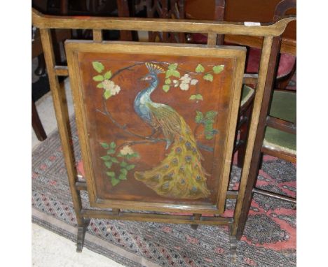 An oak framed fire screen, the centre panel of embossed and painted leather depicting a peacock on a branch