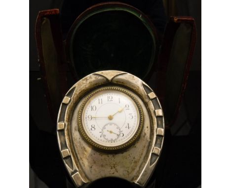 A Victorian silver mounted travel clock in the form of a horseshoe, the white enamel dial set with Arabic numerals and second