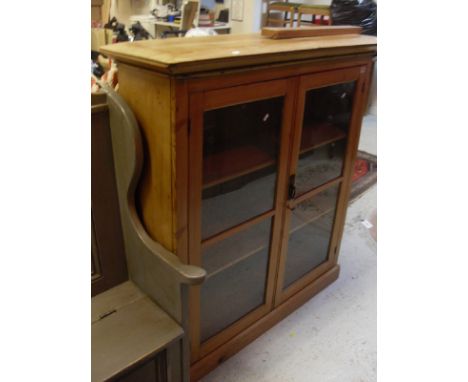 A pitch pine two door glazed cabinet of two shelves